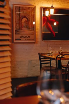 an empty restaurant with tables and chairs in front of a painting on the brick wall