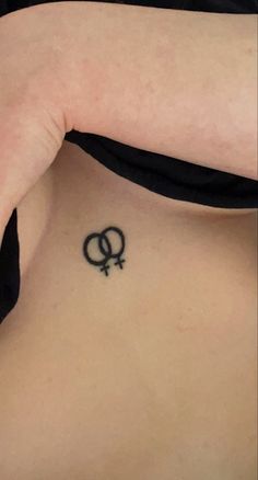 a woman with a tattoo on her back showing the symbol of two interlocked circles