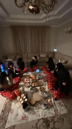 several people sitting around a table with food on it