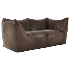 a large brown leather couch sitting on top of a white floor