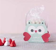 an owl treat bag with candy in it and two little red ones next to it