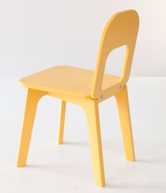 a yellow plastic chair sitting on top of a white floor