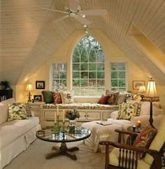 a living room with couches, chairs and a table in front of a window