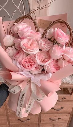 a basket filled with pink flowers on top of a table