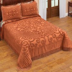 an orange bedspread with tassels on it