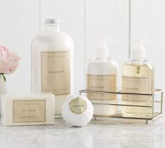 a marble counter top with soap, lotion bottles and flowers in vases on it