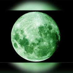 the green moon is lit up in the dark sky