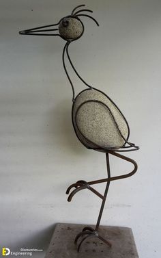 a metal bird sculpture sitting on top of a table