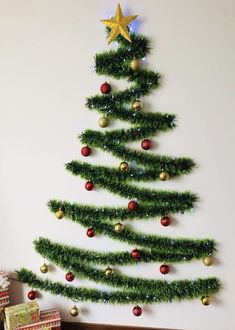 a christmas tree made out of tinsel and ornaments on the side of a wall