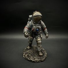 an astronaut figurine on a black background