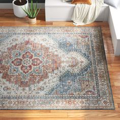 a large area rug with an ornate design on the floor in front of a window