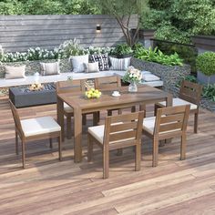 a wooden table and chairs sitting on top of a hard wood floored patio area