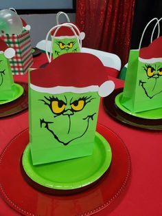 green paper bags with angry faces on them sitting on top of a red table cloth