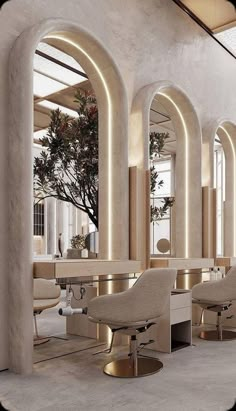 the interior of a hair salon with chairs and tables in front of large arched windows