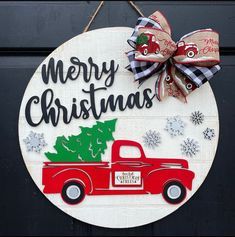 a red truck with a christmas tree on the back is hanging from a black door