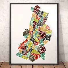 a framed map of the city of new york in different colors and sizes on a wooden floor