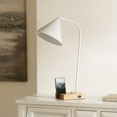 a white lamp sitting on top of a table next to a phone