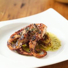 some food on a white plate sitting on a wooden table