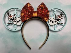 a minnie mouse ears headband with an image of bugs on the side and gold sequins