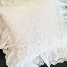 two white ruffled bedspreads on top of each other with lace trim around the edges