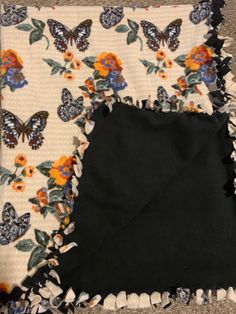 two pieces of black fabric with butterflies on them and one piece of white material in the middle