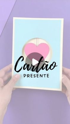 someone holding up a card with the words cartao presente on it in front of a purple background