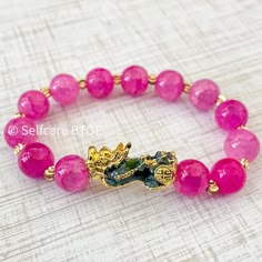 This Feng Shui bracelet is made with Pink Jade Natural Stone and is a beautiful work of artistry. Our Pixiu or Pi Yao bracelet, also known as the wealth and good luck bracelet, comes in two pink shades: Flamingo and Bubblegum pink. If you are looking for a sparkly girly addition to your collection, then this is what you need. The Feng Shui Bracelet or Pixiu Bracelet is a powerful piece of jewelry used in Asian cultures to attract wealth, good luck, and fortune into their homes, businesses, or wo Jade Bracelets With Round Beads For Gifts, Adjustable Gemstone Beads Bracelets For Good Luck, Spiritual Jade Beaded Bracelets With Spacer Beads, Crystal Bracelet With 108 Beads As A Gift, 108 Beads Bracelet Jewelry Gift, Jade Bracelets With Spacer Beads As Gift, Pink Adjustable Jade Jewelry, Gold Jade Crystal Bracelet Gift, Pink Jade Jewelry As A Gift