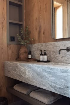 a bathroom with marble counter tops and wooden walls