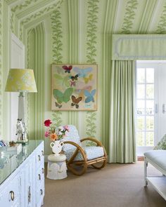 a room with green wallpaper and white furniture