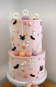 a three layer cake decorated with spooky decorations and ghost faces on the side