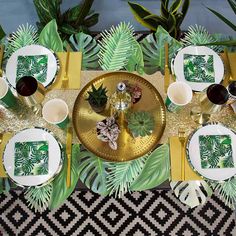 a table set with plates, silverware and green napkins on top of it