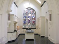 an empty church with stained glass windows and white cabinets