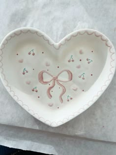 a heart shaped dish with a bow on it