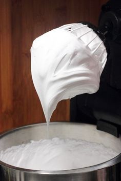 a person pouring milk into a large pot