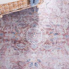 a large rug with an ornate design on the bottom, and a wicker basket sitting next to it