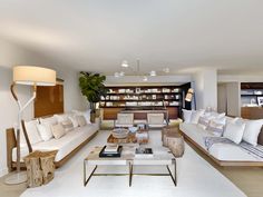 a living room filled with lots of furniture and bookshelves on top of each other