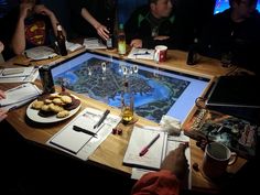 a group of people sitting around a wooden table