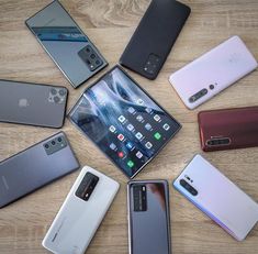 many different cell phones are arranged in a circle on a table with one open and the other closed