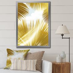 a living room with a white couch and yellow palm leaves on the wall above it