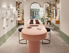 a long table with glasses on it in the middle of a room filled with shelves