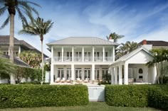 a large white house surrounded by trees and bushes