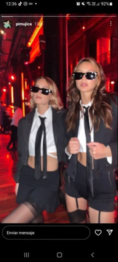 two women dressed in black and white posing for the camera with sunglasses on their faces