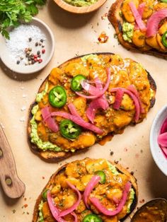 two pieces of bread with different toppings on them next to bowls and spoons