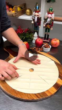 a person cutting up food on top of a wooden board