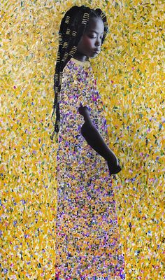 a woman standing in front of a yellow wall with confetti all over it