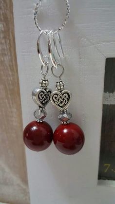 two red beads hanging from a hook on a white door with a chain attached to it