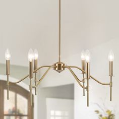 a chandelier with five lights hanging from it's sides in a living room