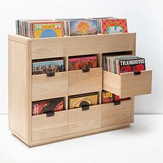 a wooden storage unit with cd's and cds