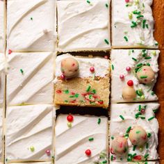 several pieces of cake with white frosting and sprinkles on them, cut into squares