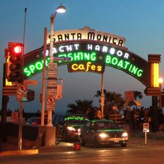 cars are driving under an arch that reads, santa monica yacht harbor fishing boating cafe